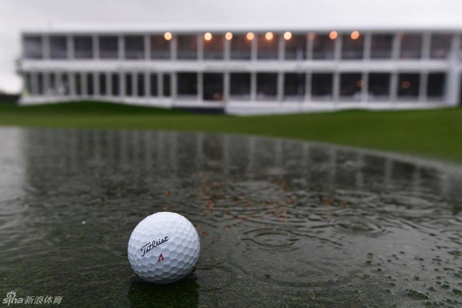 球员们身披雨衣在暴雨中坚持比赛，雨滴模糊了他们的身影，展现了职业高尔夫的另一面