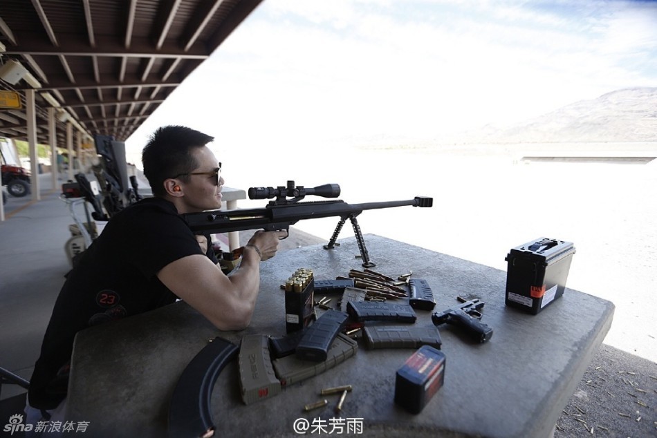 与友人并肩而立的合影中，朱芳雨依旧保持着标志性的微笑，手中的狙击枪为这次异国特训增添了一份特别的回忆，画面中充满了轻松愉快的氛围。