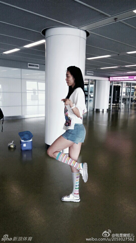 赵爽俏皮地侧身屈膝，做出一个炫酷的武术起手式，脸上却挂着与动作不符的甜美笑容，瞬间从运动员切换到了“卖萌模式”，大长腿在草地上划出优美的线条。