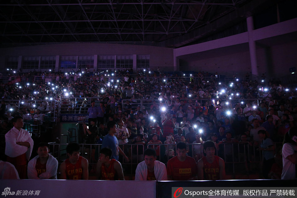获胜后的国奥球员们聚拢在一起，脸上洋溢着灿烂的笑容，远处的看台上依旧有球迷亮着手机，仿佛要用光芒留住这难忘的胜利瞬间。