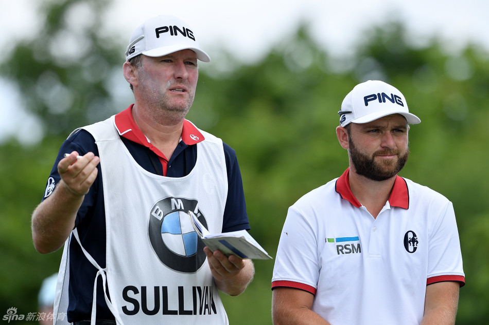 安迪·苏利文与他的球童并肩站在球道上，手指远方，共同商讨下一击的策略