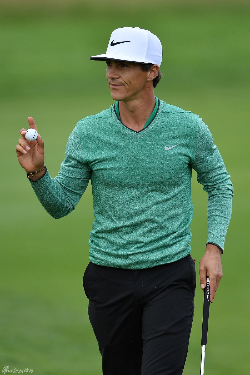 泰国高尔夫名将阿费巴拉特在果岭上俯身，眼神锐利地聚焦于小球与球洞线