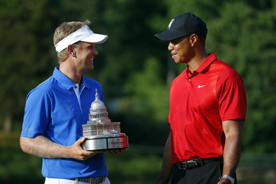 老虎伍兹面带微笑，将沉甸甸的冠军奖杯递到新科冠军赫尔利三世手中，背景是国会乡村俱乐部的经典景致。