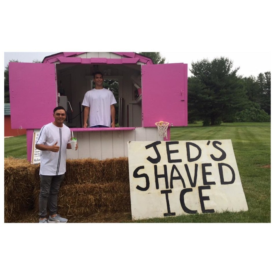 夕阳西下，结束游览的球星放松地倚在车边，享受着一杯清凉饮料，远处是归巢的飞鸟