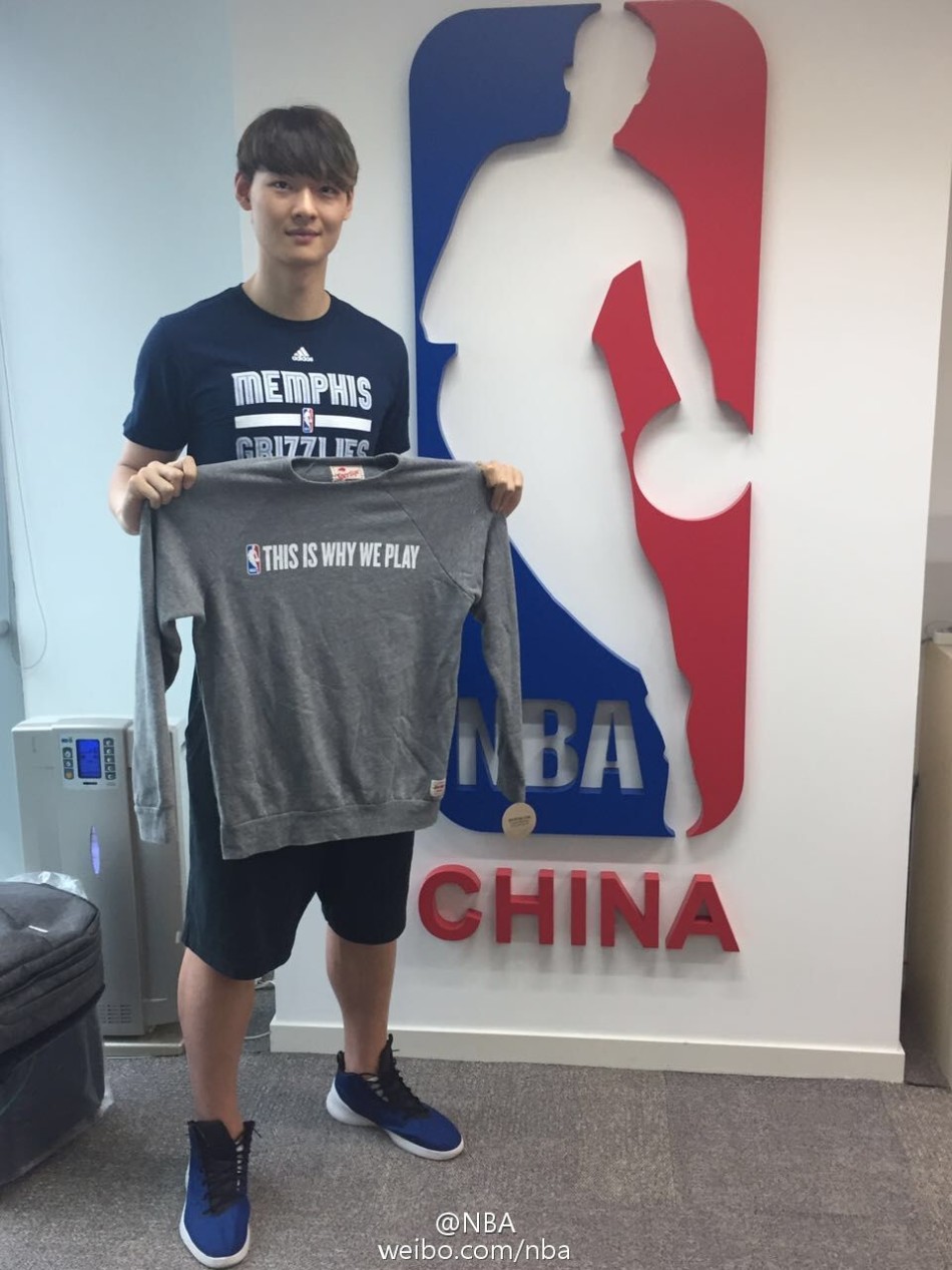站在NBA中国总部的标志前，王哲林的身姿显得格外挺拔，这张合影是他篮球人生新篇章的郑重落笔。