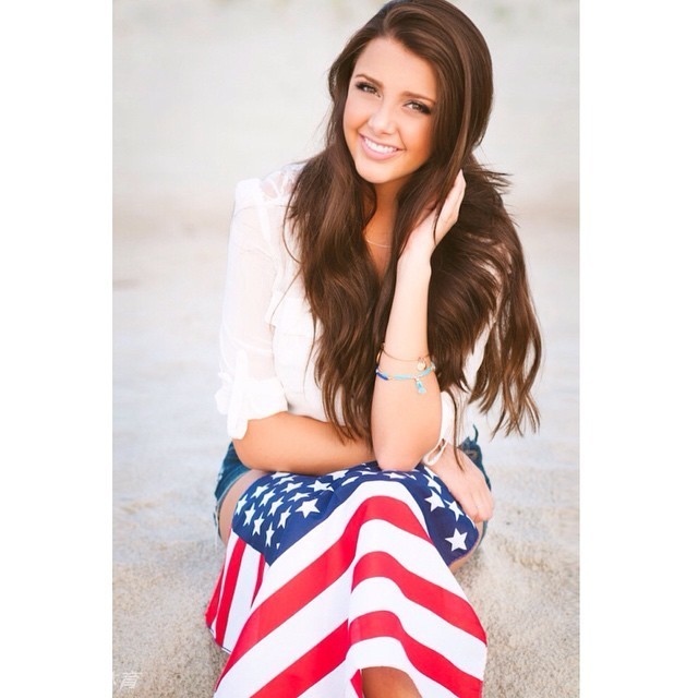 海边黄昏，玛琳娜化身灵动美人鱼侧坐浅笑，粼粼波光映衬着她曼妙的身姿，仿佛刚从童话中游弋而出