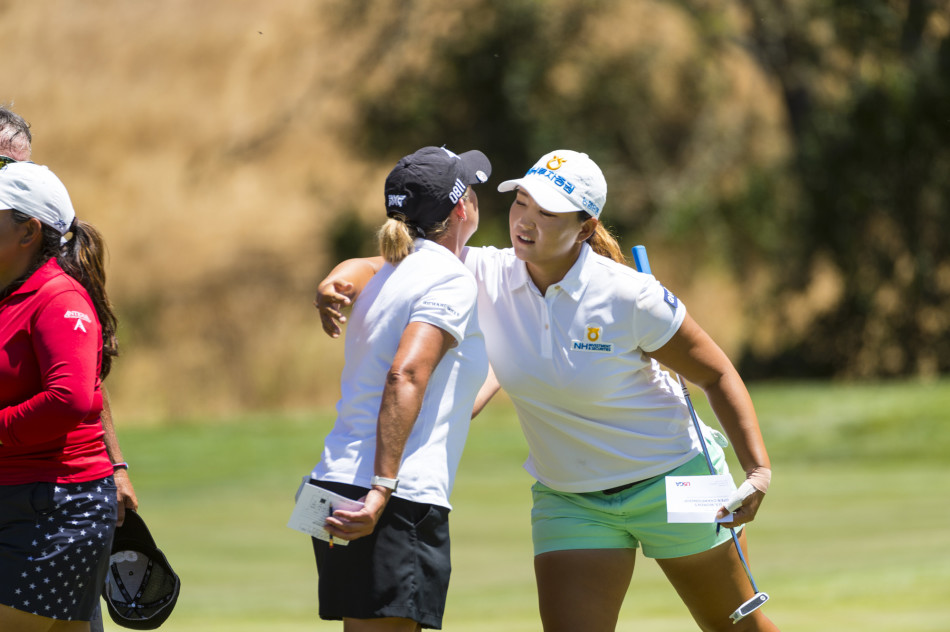 魏圣美在发球台全力挥杆，白色上衣与绿色背景构成动人画面