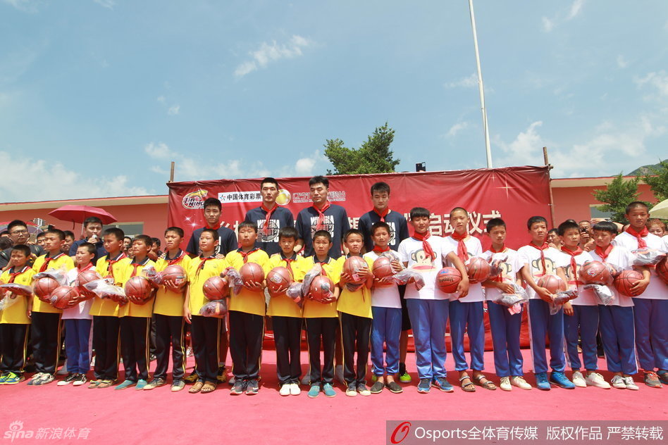 辽篮主教练郭士西坐在校园的椅子上，神情专注而和蔼，准备在接下来的公益活动中向孩子们和乡亲们讲话。