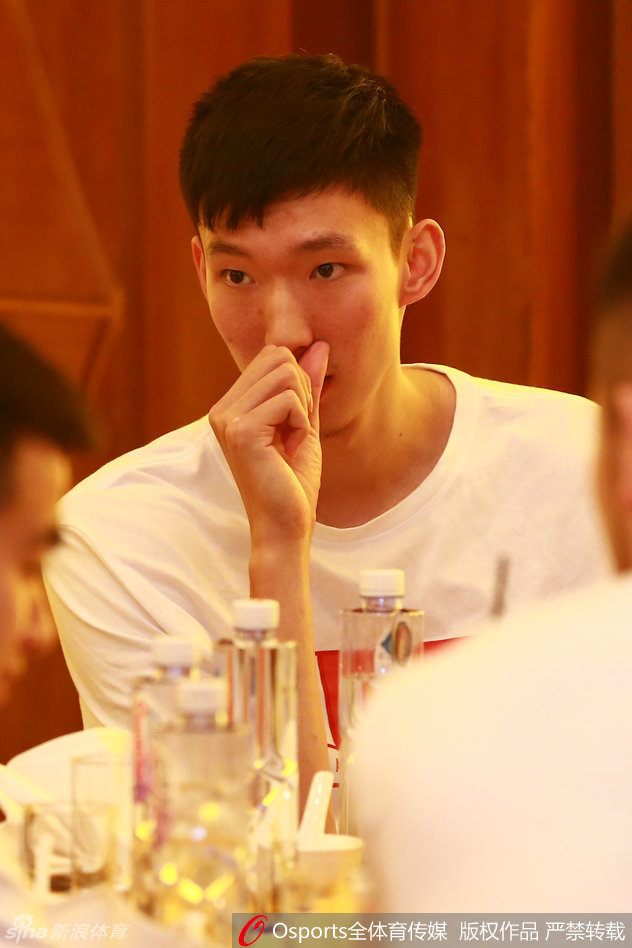 更衣室角落里，周琦和王哲林并肩而坐，两人低头看着手机屏幕，沉默中似乎还在回味着刚才的比赛，年轻的面庞上写满了不甘。