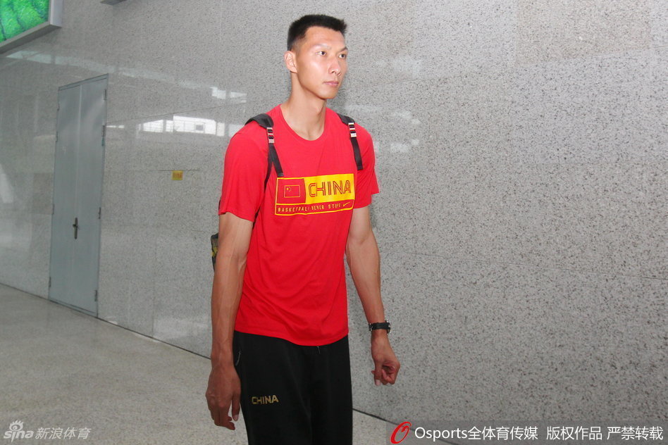 易建联在法国队员严密防守下依然神情坚毅，高高跃起投出关键一球