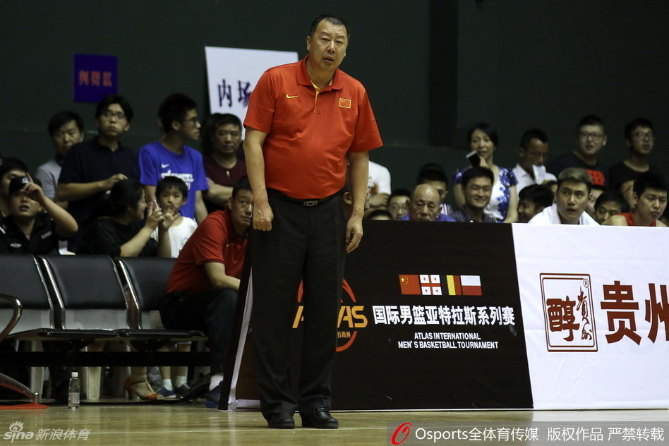 朱荣振完成单手扣篮后，身体仍在篮圈上轻微摆动，背景是模糊的观众席，这一刻的震撼与骄傲属于这个年轻人。