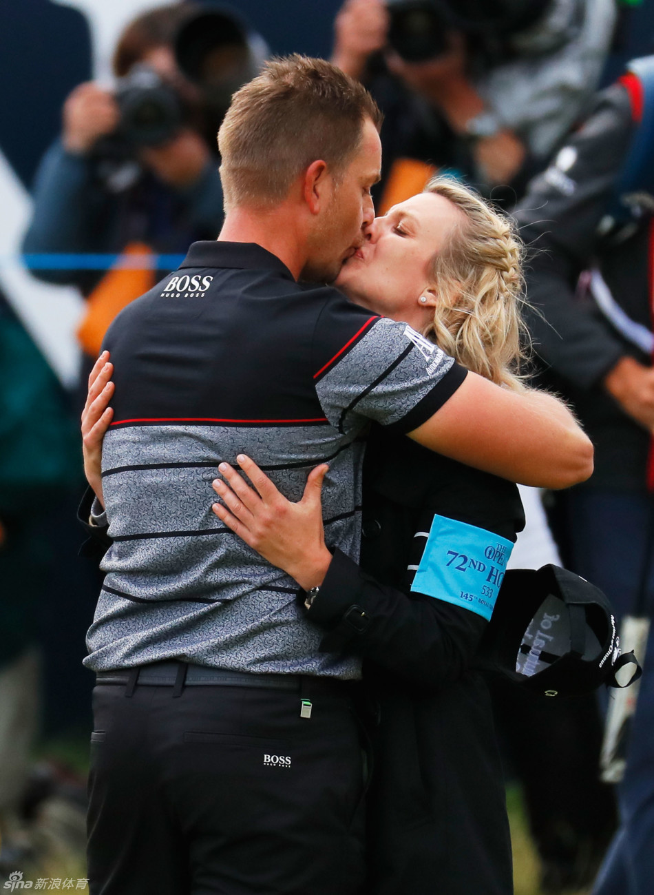 斯滕森高举葡萄酒壶,在皇家特隆古老会馆的背景下,与现场观众分享胜利狂喜