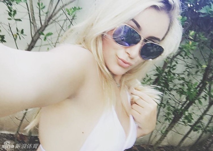 球手在沙坑中全神贯注救球，扬起一片金色沙雾，背景是辽阔无垠的湛蓝大海