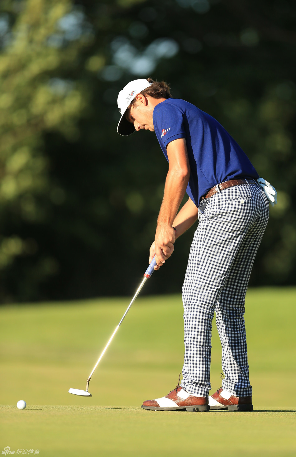 安德烈斯-冈萨雷斯以他标志性的浓密胡子造型亮相赛场，正与球童讨论球位策略