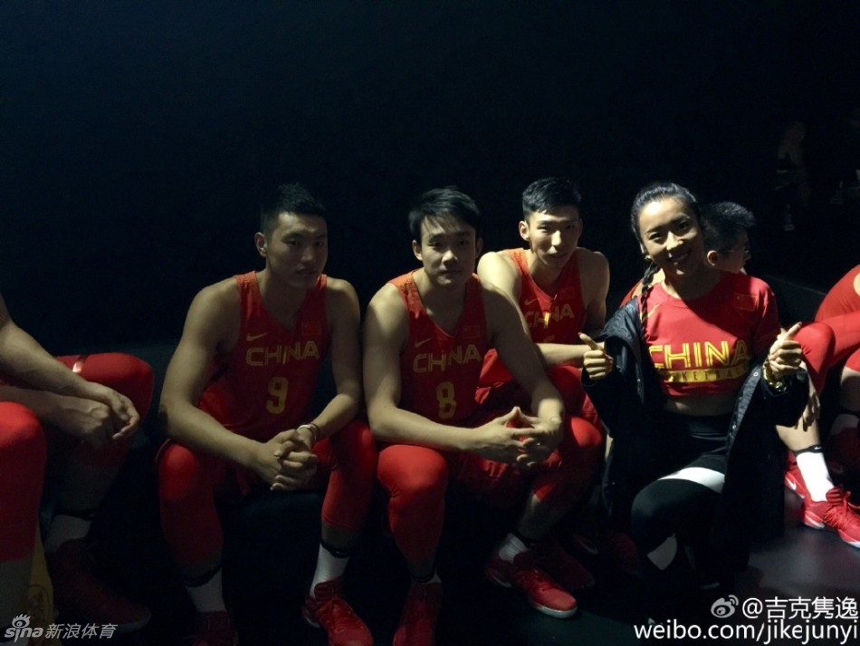 台下合影时，吉克隽逸笑容灿烂地坐在男篮队员中间，她身上那抹红色不仅是中国队的象征，也点燃了现场热烈的助威气氛。