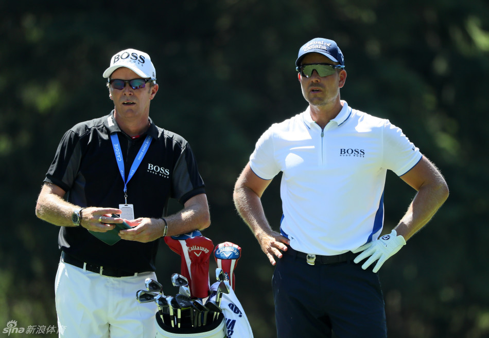 两位球员在练习果岭上轻松交流,远处夕阳为训练日画上宁静句点