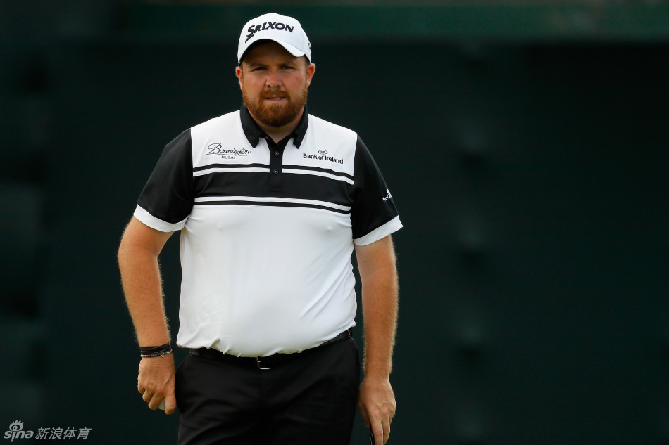 高尔夫球童在沙坑中将球杆递给球员，两人眼神交流，默契尽显，是赛场上无声的伙伴。