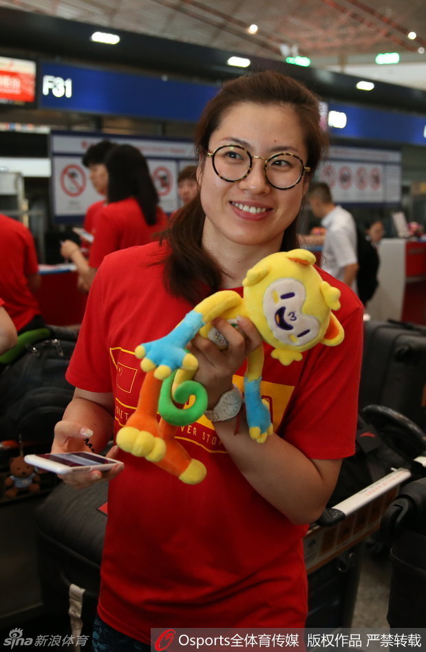 高颂在合影时用手揉着眼睛，脸上带着一丝长途旅行前的疲惫。连续的集训和热身赛让身体有些透支，但为了里约的梦想，她依旧精神饱满地踏上了征程。