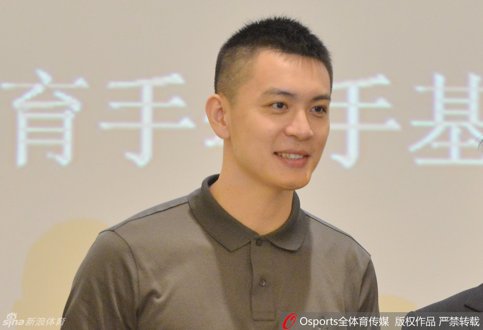 身姿挺拔的杨鸣站在演讲台前，手中握着演讲稿，眼神温柔而坚定地望向台下学子。