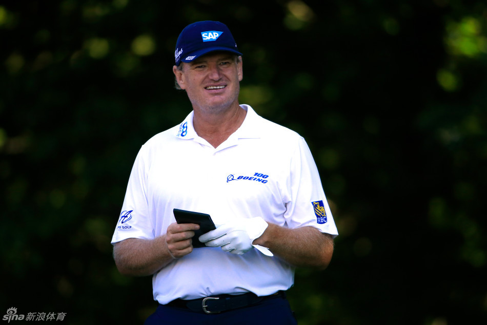 布鲁克斯-科普卡在旅行者锦标赛的果岭边半跪，深邃的目光凝视着球路，肌肉线条在阳光下分明，展现顶级球员的绝对专注与力量感。