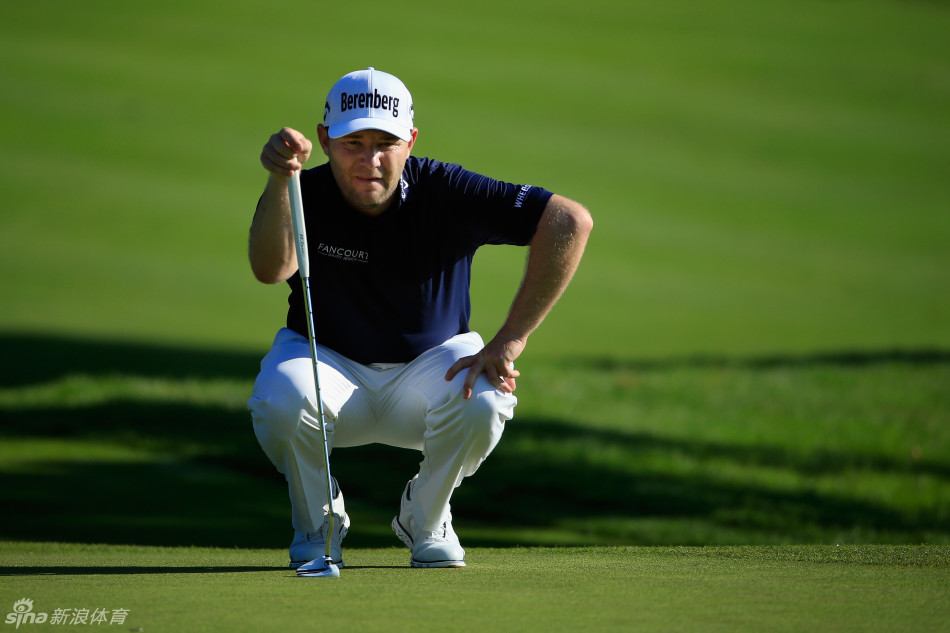 保罗-卡西与临时球童在果岭边低声讨论攻果岭的策略，两人神情专注