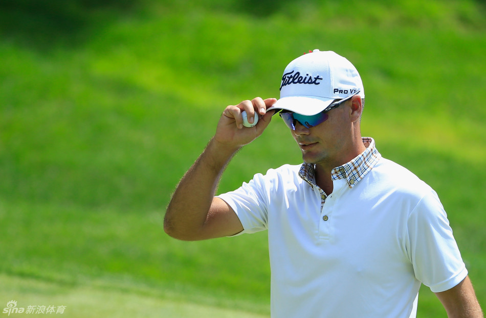 观众聚集在景色秀丽的湖边球道旁，聚精会神地观看球员的精彩击球