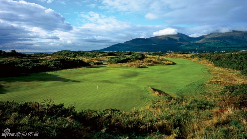 皇家邓恩郡尔夫俱乐部的金色春天：金雀花在古老的沙丘上盛放，湛蓝的邓德拉姆湾与莫恩山脉构成壮丽背景