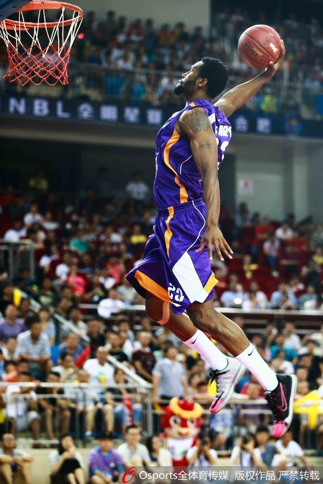 进攻球员在三人包夹之下，依然冷静地将球放入篮筐，展现出极佳的空中平衡感。