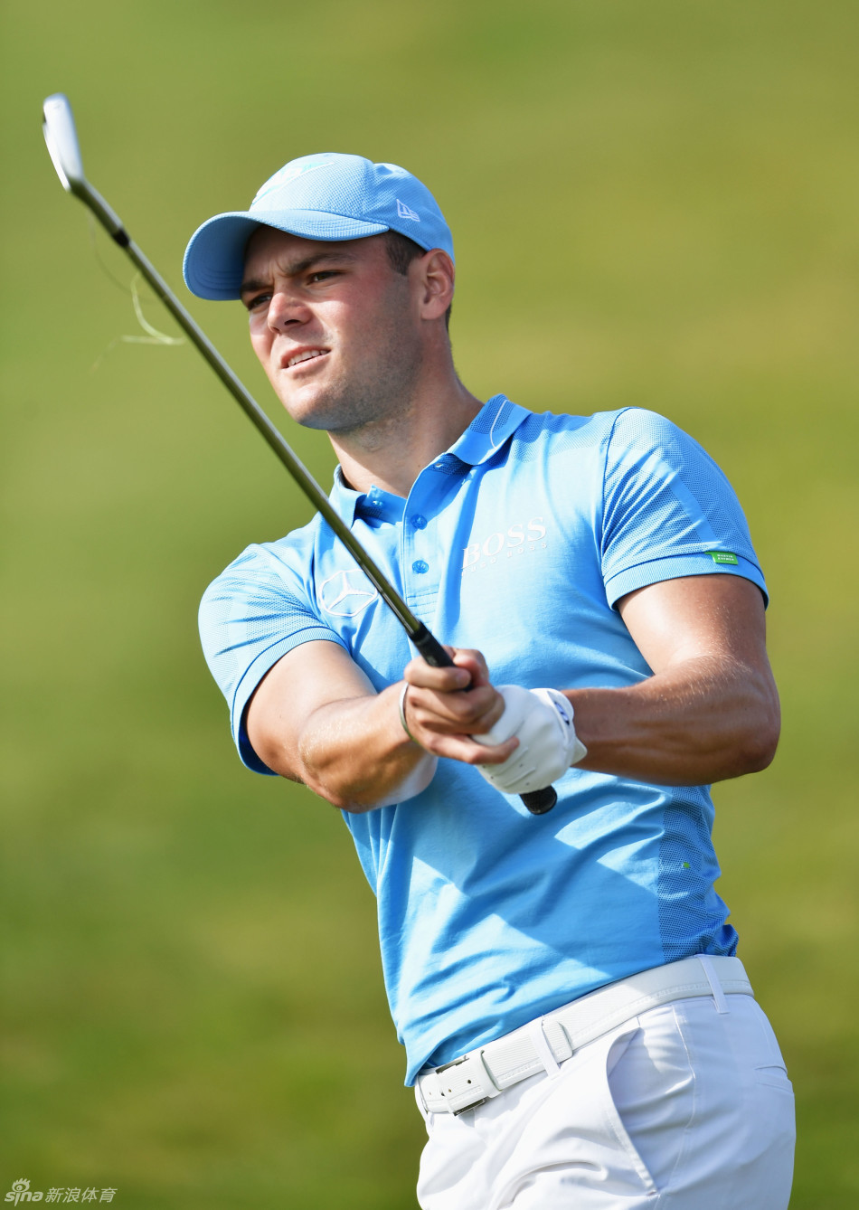 凯梅尔正在果岭边仔细观察推杆路线，他微微屈膝，从球后方向洞杯方向凝视，评估着果岭的微妙起伏。