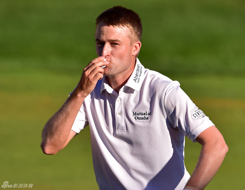 诺克斯深情亲吻着旅行者锦标赛冠军奖杯，脸上洋溢着梦想成真的灿烂笑容。