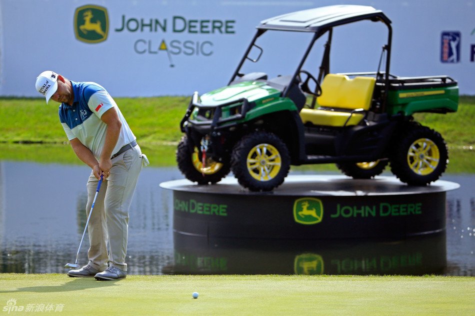 扎克·约翰逊在果岭上单膝跪地，从最佳角度读取推杆线路的细微转折