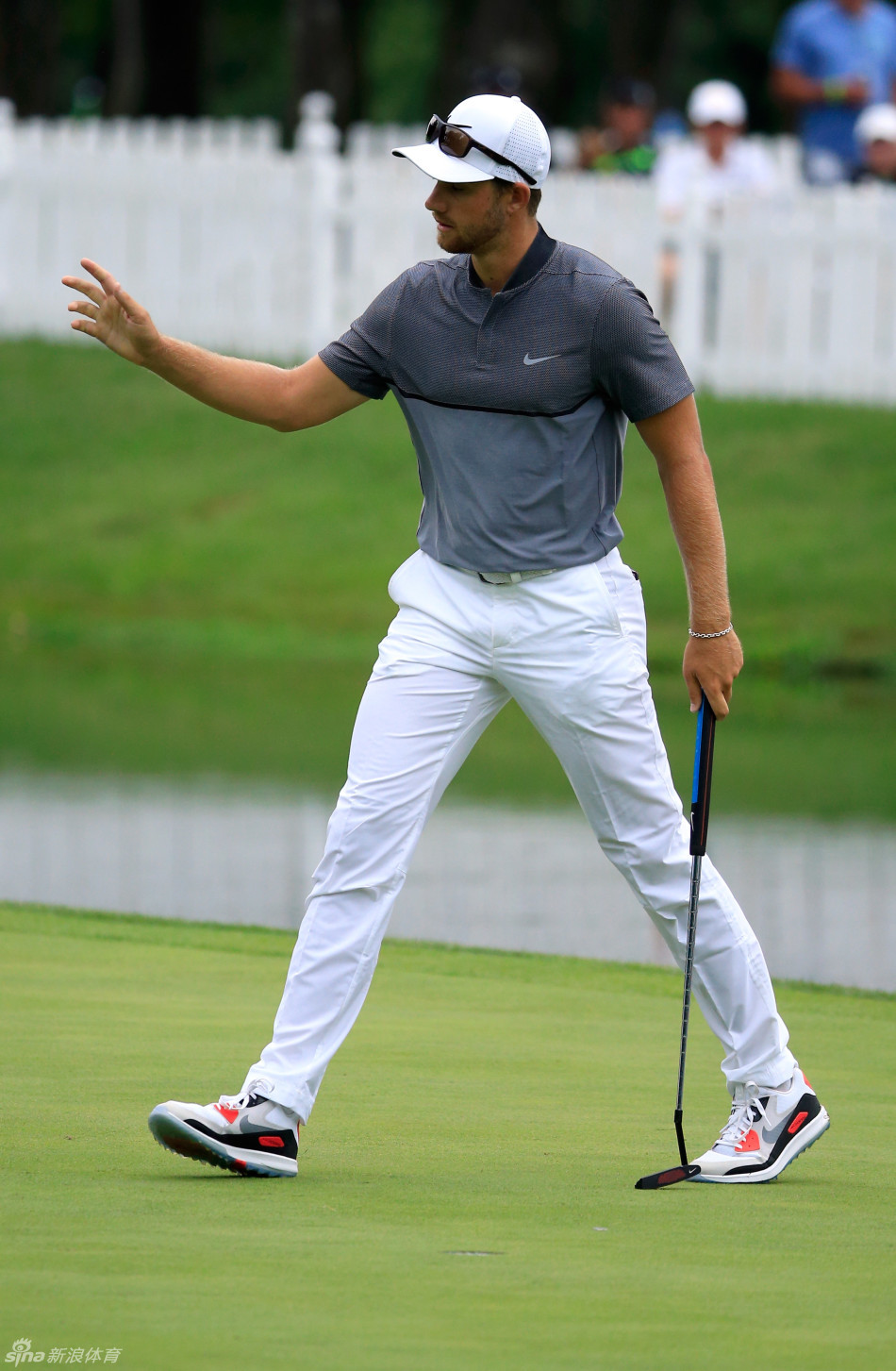 赖安·摩尔在18号洞果岭俯身观察，准备推入锁定冠军的最后一推