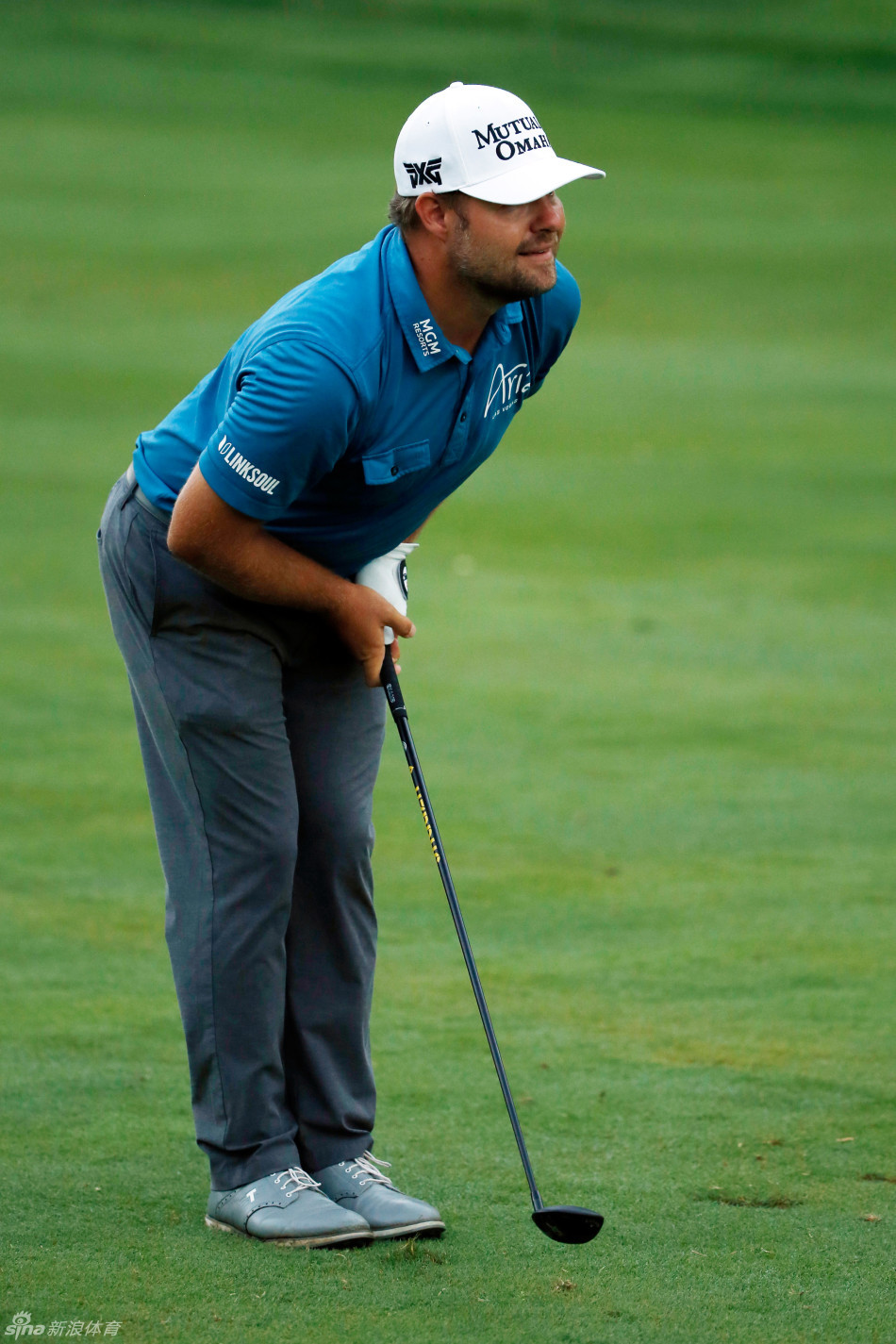 扎克·约翰逊在发球台上全力挥杆的瞬间，身体充分扭转，彰显力量与技巧的融合。