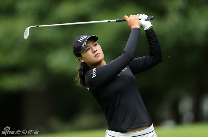 中国名将冯珊珊在发球台眺望球道，微风拂过她的发丝，奥林匹克五环标志在身旁熠熠生辉