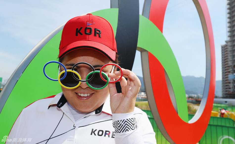 里约奥运高尔夫球场全景，绿意盎然的球道与远处山海相连，静候世界顶尖女子球手的挑战。