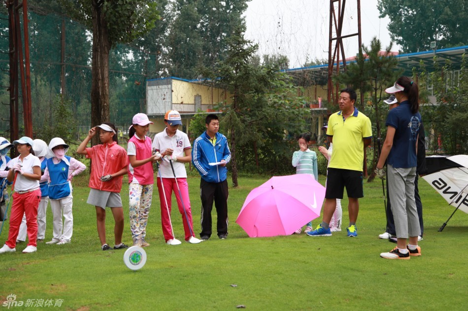 戴着遮阳帽的球手正在果岭边仔细观察推杆线路，神情专注而沉稳。