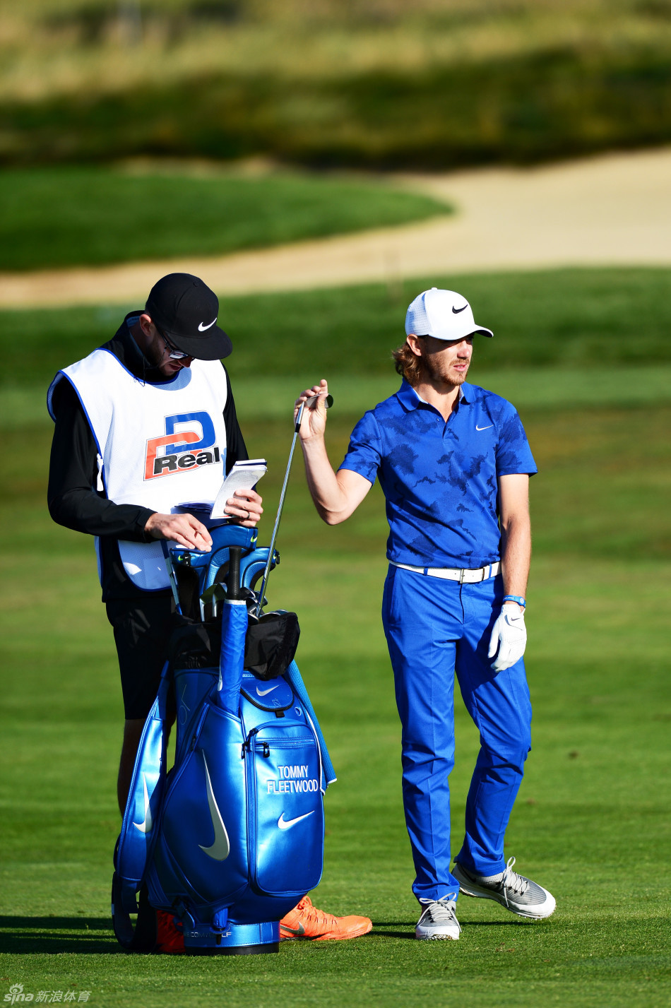 球手与球童女友在赛场边相视一笑，紧张赛程中的温情瞬间。