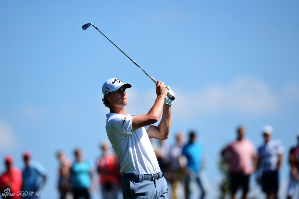 卫冕冠军托马斯·皮特斯在果岭边凝神观察推杆线路，眼神专注而坚定。