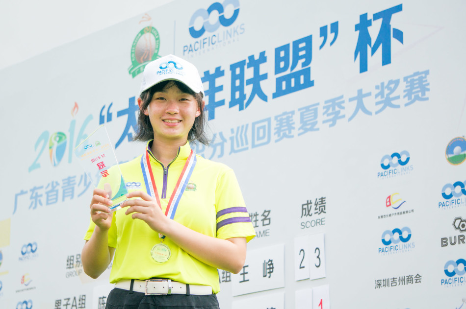 广东高协青少年队领队杨靖哲与获奖小选手并肩站立，手捧奖杯，眼中充满对未来的期许