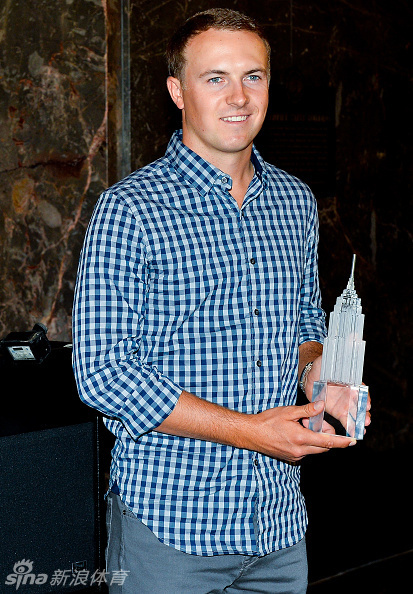 乔丹·斯皮思手持联邦杯冠军奖杯,在帝国大厦的观景台上向纽约的天际线致意。