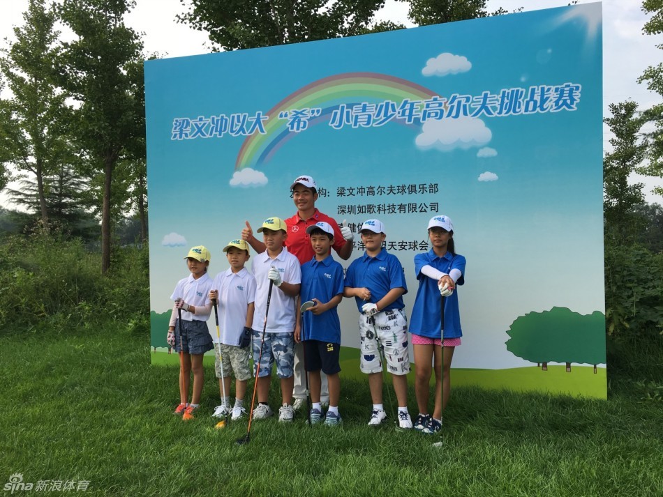 梁文冲与青少年球员们在天安球会出发台前精神抖擞地合影，充满期待的早晨