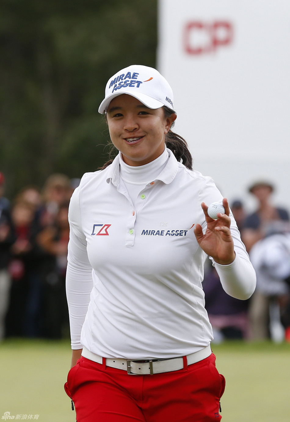 韓國選手金世煐在果嶺邊緣凝視球路，她表情專注，微微蹙眉，身著白色外套，在清冷天氣中為關鍵一推做最後準備。