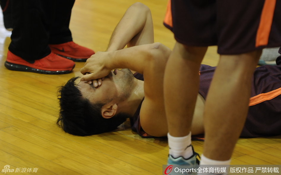韩德君坐在场边长凳上，魁梧的身躯此刻却显得无比落寞，他双手抱头久久不愿抬起，似乎无法接受队友重伤的事实，背影写满了担忧与心痛。