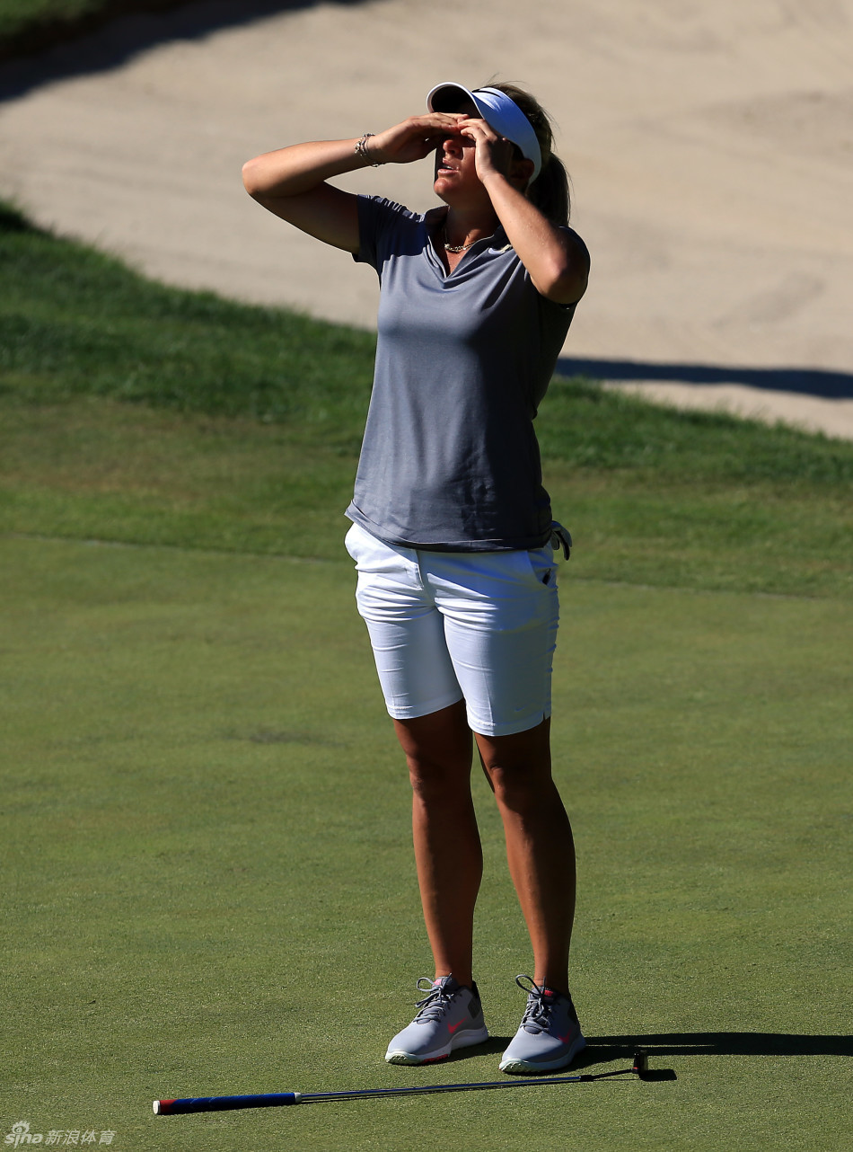 苏珊彼得森在果岭上俯身，神情专注地查看小鸟推杆的路线，成败在此一举