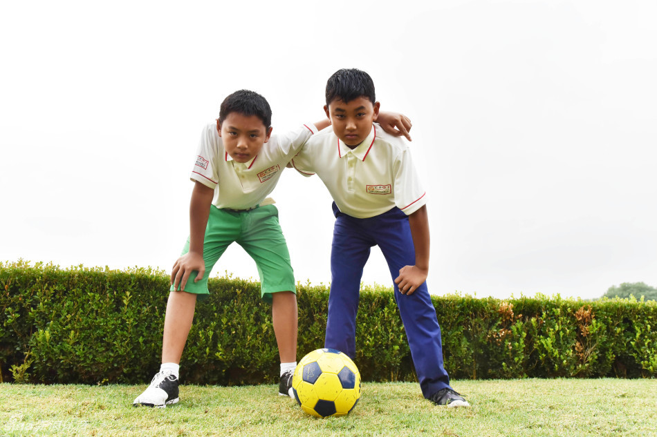 周子勤与张中昱在绿茵场上激烈拼抢，足球在两人之间快速传递，充满动感