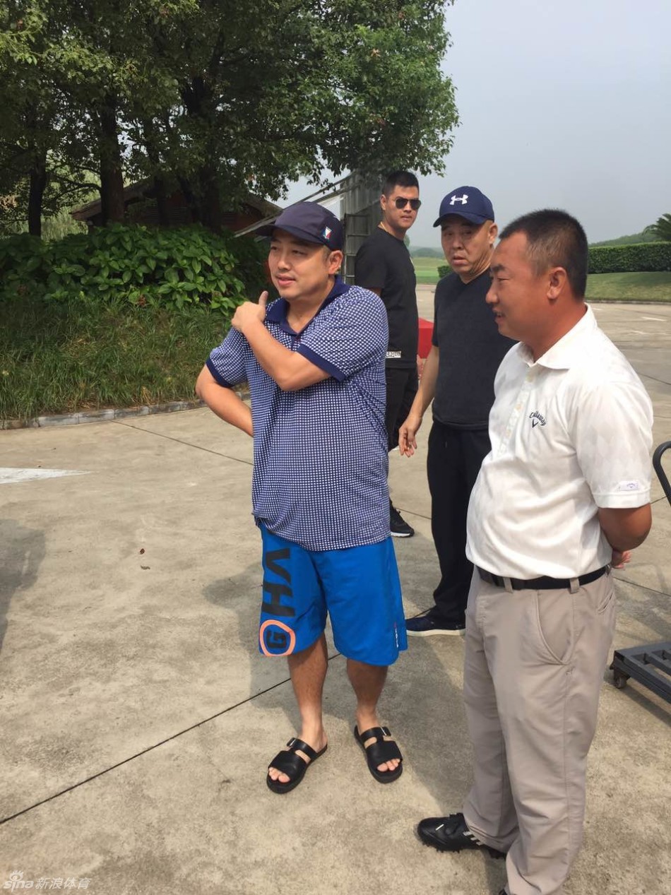 刘国梁俯身与小小粉丝合影，脸上洋溢着亲切的笑容，赛场外的他毫无冠军教头的架子