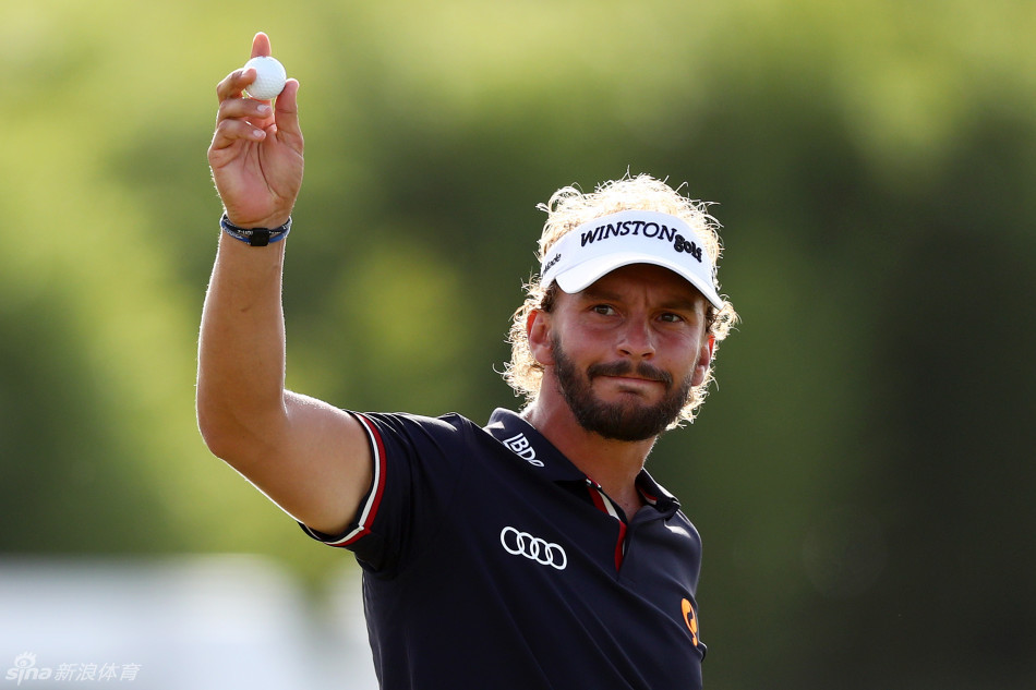 海顿-克鲁格在荷兰人高尔夫俱乐部第十八洞果岭审视推杆线路，背景中的赞助商标志见证着冠军的决胜时刻