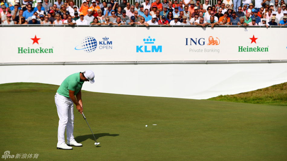 荷兰本土球员朱斯特-莱腾在果岭边轻柔放置高尔夫球，并竖指示意，神情专注地为重要推杆做准备