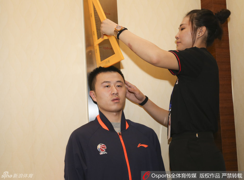 刘晓宇正准备进行身高测量，他脱掉鞋子站上仪器，一双长腿在人群中格外显眼，尽显控卫的身体天赋。