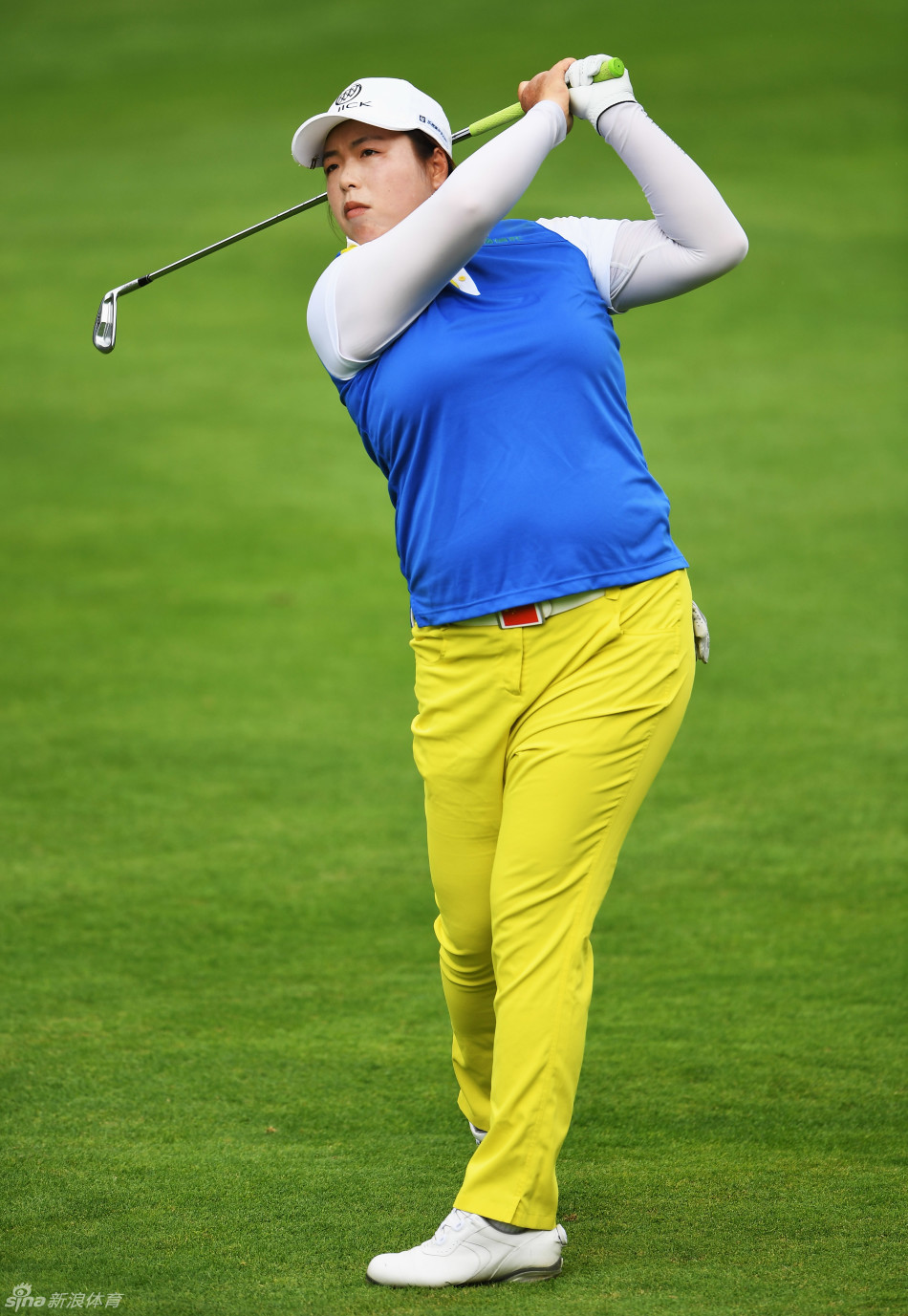 冯珊珊在依云锦标赛球道上专注准备开球，身后是起伏的群山与赛场